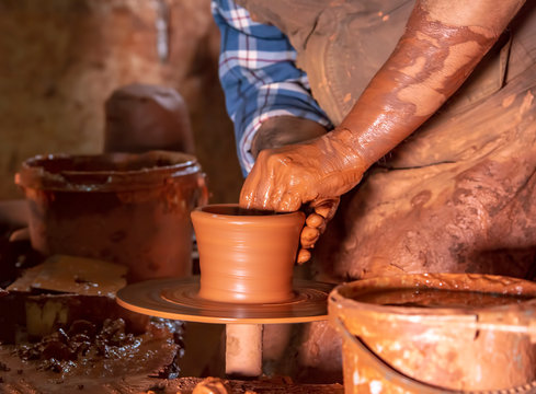 Professional potter making bowl in pottery workshop, studio.
