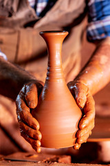 Professional potter making bowl in pottery workshop, studio.