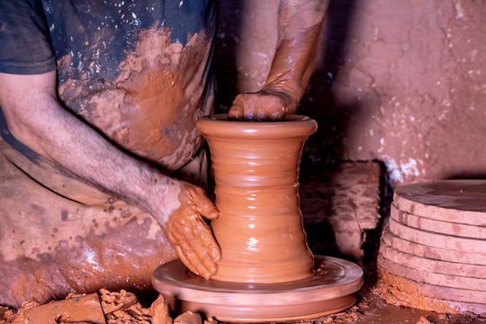 Professional potter making bowl in pottery workshop, studio.
