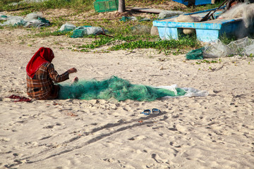 Nets for catching crabs and shrimp, woman unravels the nets