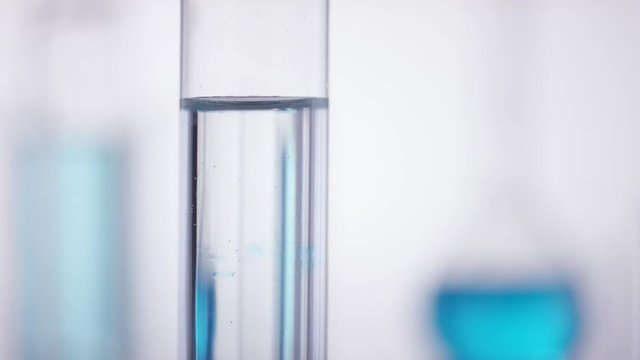 Blue chemical drops into a clean test tube