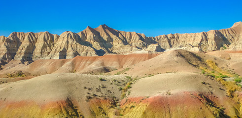 Panorama of colorful eroded pinnacles of Badlands National Park in South Dakota, United States. American travel destination. Summer blue sky with copy space. © bennymarty