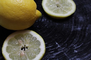 Zitronenscheiben auf schwarzem Holzuntergrund