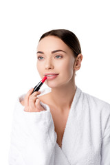 beautiful woman in bathrobe applying red lipstick isolated on white