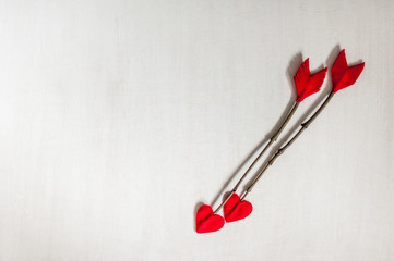 Valentines day twig arrows on white wooden background. Handmade cupid's arrows. Top view. Soft focus.Space for text.
