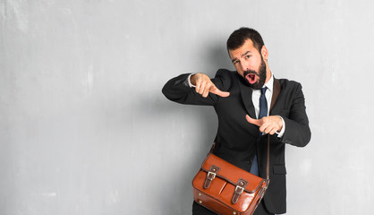 Businessman with beard pointing with finger at someone and laughing a lot