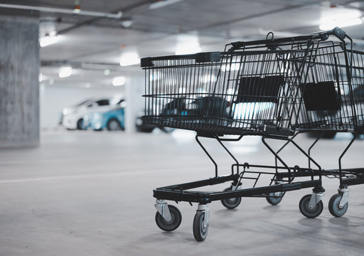 two empty shopping cart and blurred car at parking lot, winter color tone