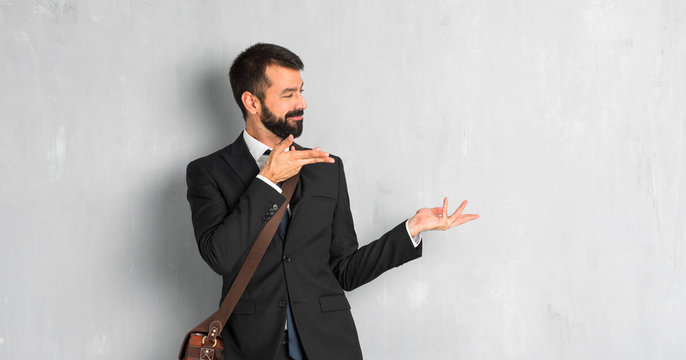 Businessman with beard extending hands to the side for inviting to come