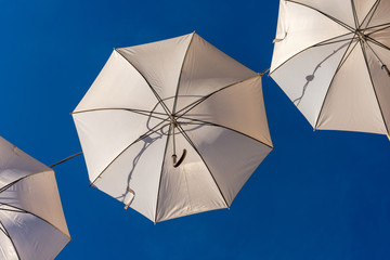 White umbrellas on a clear blue sky