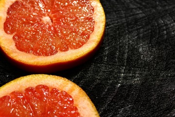 Grapefruitscheiben auf schwarzem Holzuntergrund