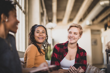 Smiling friends sitting at home