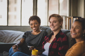 Young adult friends socialising in a loft apartment