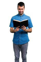 Handsome man with blue shirt reading a book