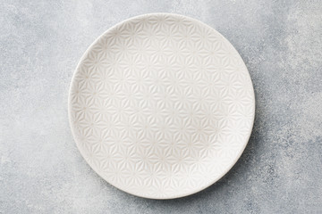 Empty plate on cement background. Top view with copy space