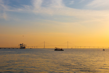Fototapeta premium Scenery with Incheon Bridge and ship. Beautiful sea bridge. Incheon Bridge with sunset.