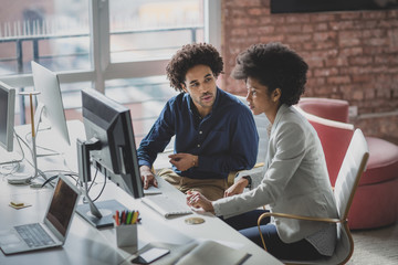 Coworkers looking at a desktop computer together