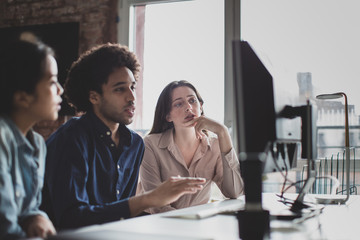 Coworkers looking at a desktop computer together