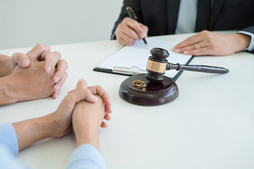 Judge gavel with Justice lawyers deciding, consultation on marriage divorce between married couple and signing divorce documents on table. Concepts of Law and Legal sevices.