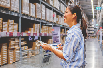 Asian woman with market trolley at furniture store