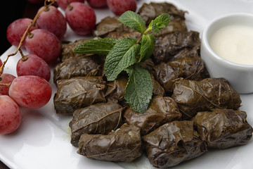 Azerbaijani dolma in grape leaves on a white plate