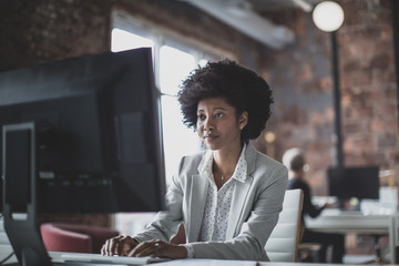 Female african american business executive working in an office on a desktop computer