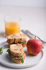 Homemade sandwiches prepared with fresh vegetables and olive oil. Healthy breakfast with orange juice and fruits