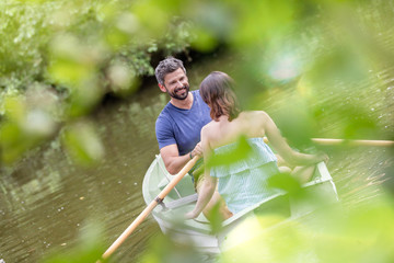 Tilt shot of happy mid adult couple boating in lake during summer