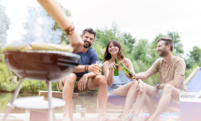 Happy friends enjoying summer weekend on pier