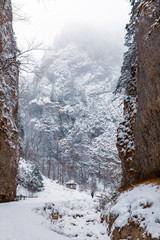 Landscape with a road covered with snow through a canyon