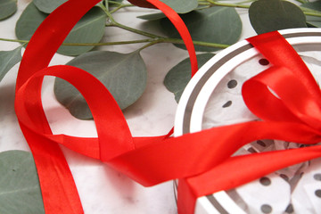 Beautiful bright red rose petals on a light background. Happy Valentine's day. Gift with red ribbon and bow