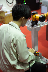 Industrial technician operate robot arm to loading workpiece. Industry manufacturing