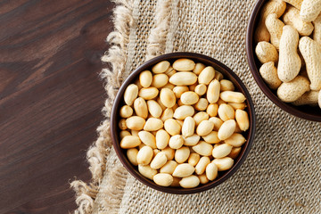 Peanuts in the shell and peeled closeup in a cup