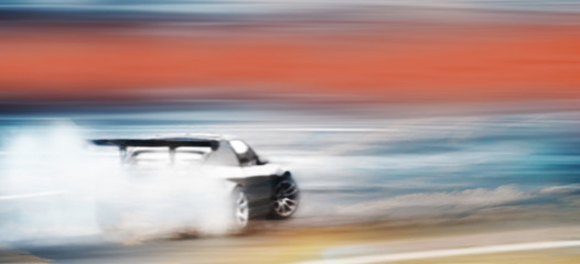 Panorama car drifting, Blurred of image diffusion race drift car with lots of smoke from burning tires on speed track