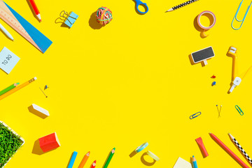 School supplies on yellow table. Top view.