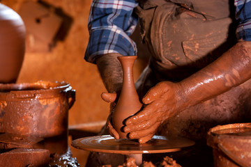 Professional potter making bowl in pottery workshop, studio.