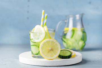 Detox Water with Cucumber and Lemon Summer Drink in Glass Jars on Blue Concrete Background Horizontal