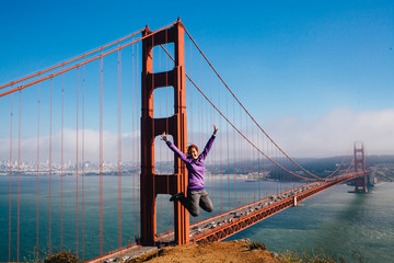 Woman jumping in front of the Golden Gate