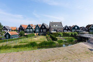 Fototapeta na wymiar streets and houses of Marken, Netherlands, Europe. Green gardens and blue sky on a sunny day
