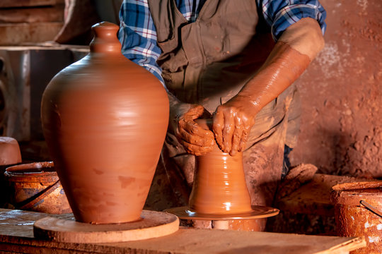 Professional potter making bowl in pottery workshop, studio.