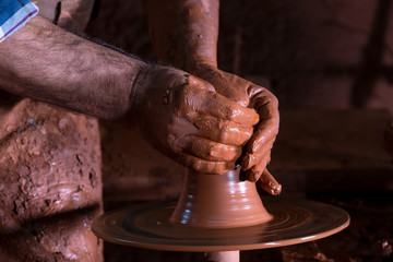 Professional potter making bowl in pottery workshop, studio.