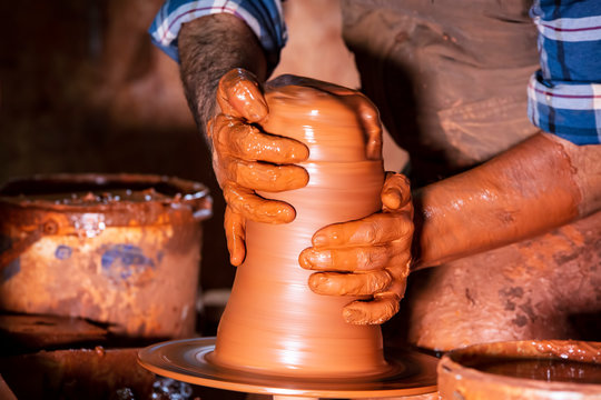 Professional potter making bowl in pottery workshop, studio.