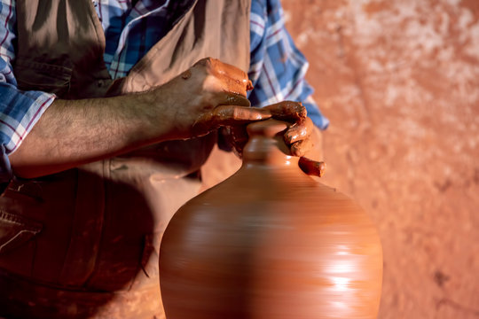 Professional potter making bowl in pottery workshop, studio.