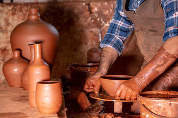 Professional potter making bowl in pottery workshop, studio.
