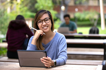 Portrait of young asian american modern female student with smart touch pad and stylus pen