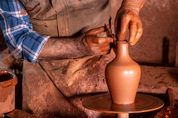 Professional potter making bowl in pottery workshop, studio.