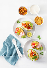 avocado boats stuffed with hummus, tomatoes, radish, roasted chickpea