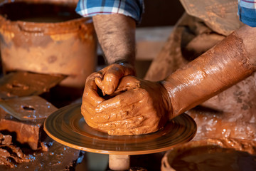 Professional potter making bowl in pottery workshop, studio.