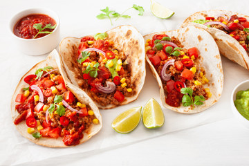 mexican beef and pork tacos with salsa, guacamole and vegetables