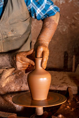 Professional potter making bowl in pottery workshop, studio.