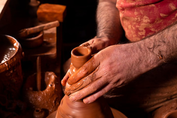 Professional potter making bowl in pottery workshop, studio.